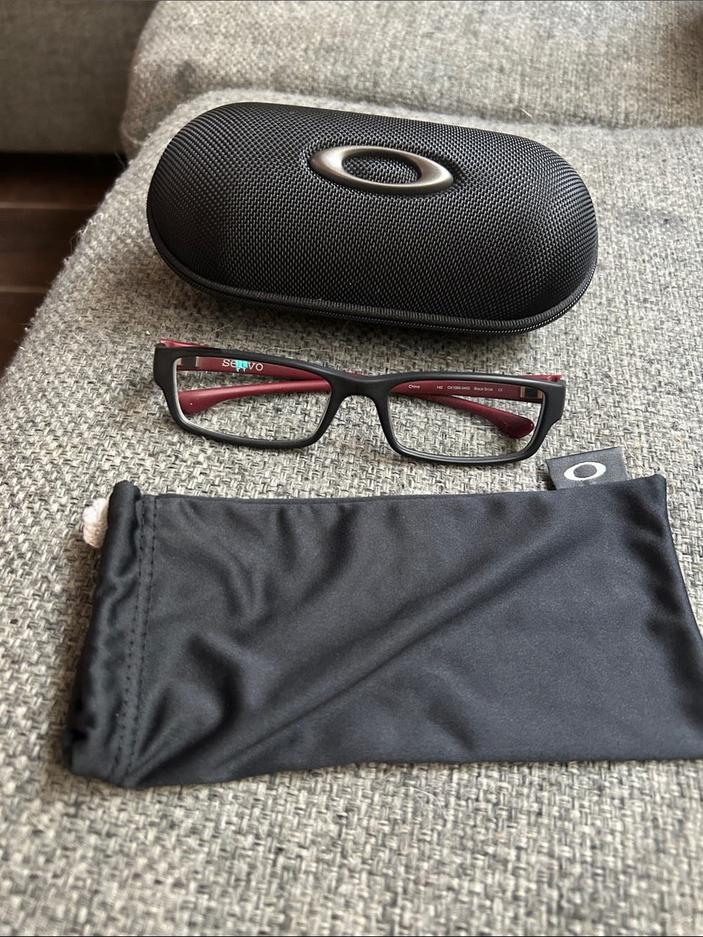 Oakley Servo Eyeglasses in black and brick-red color way with rectangular frames